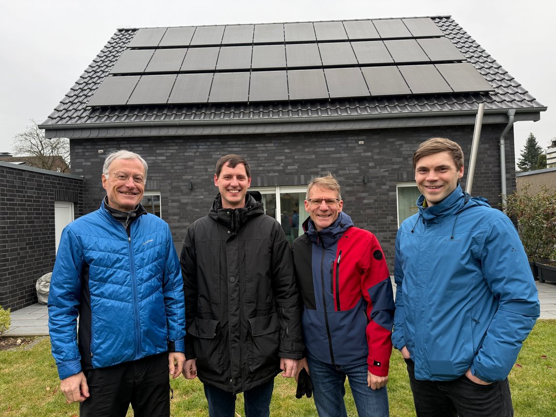 Das Foto zeigt fünf Herren vor einem Haus mit PV_Anlage auf dem Dach.