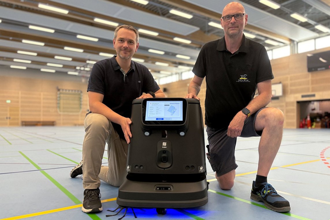 Dieses Foto zeigt Markus Friehage (l.) und André Wiesmann mit einem der beiden Reinigungsroboter