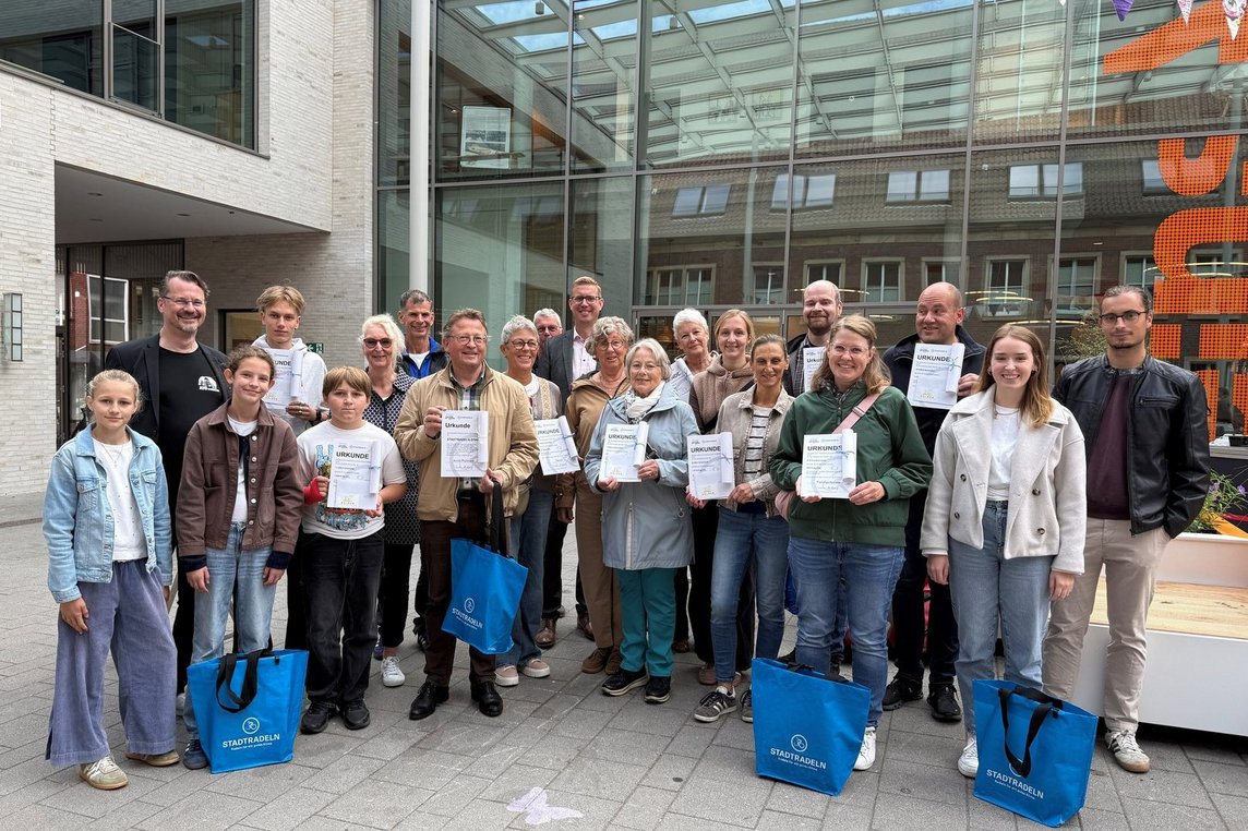 •	Auf dem Markt der Möglichkeiten zeichneten Bürgermeister Carsten Hövekamp (hinten, Mitte) und Mobilitätsmanager Lennart Mania (re.) die erfolgreichsten Teilnehmenden der Aktion STADTRADELN 2026 aus. Ein besonderer Dank ging an den wiederholten STADTRADELN-Star Arndt Pollmann (1. Reihe, 4 v. li.) (Foto: Stadt Dülmen)