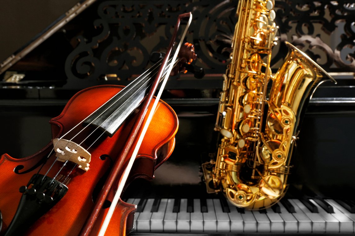 Das Bild zeigt eine Geige und ein Saxophon auf einem Klavier.