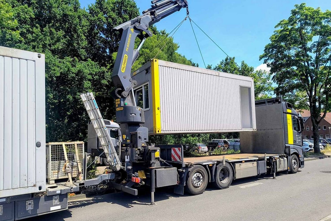 Dieses Foto zeigt einen Container, der gerade auf einen LKW geladen wird. 